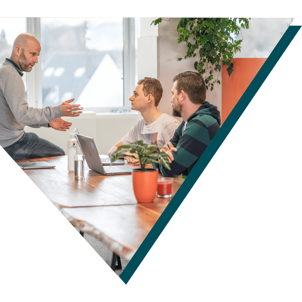 A team meeting with three men discussing at a table, representing collaborative work and brainstorming sessions at Sirus.