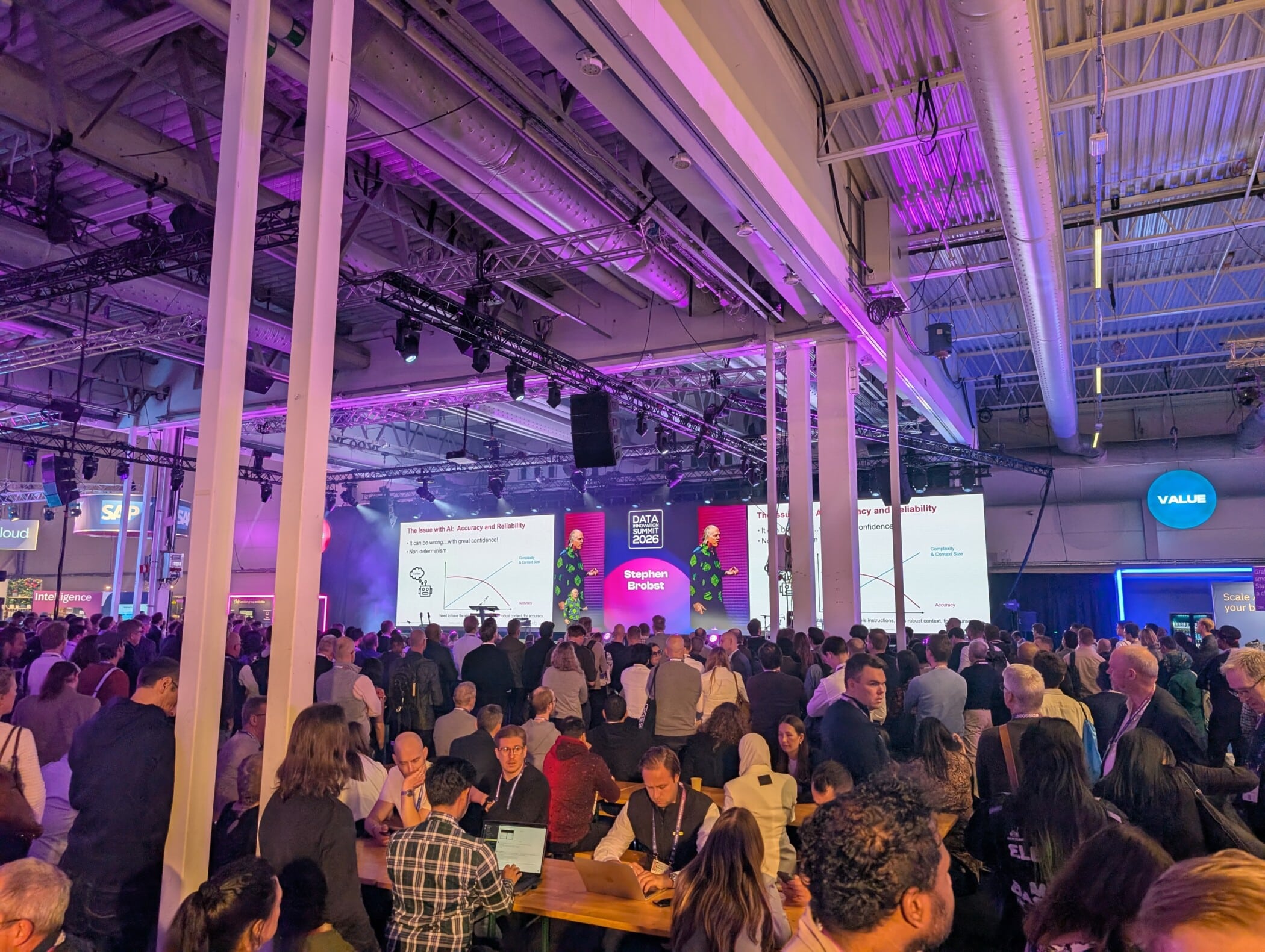 Large crowd gathered at Data Innovation Summit Stockholm conference with purple lighting and presentation screens